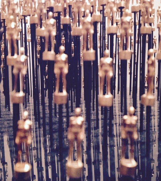 Installation of small gold figures on slender rods